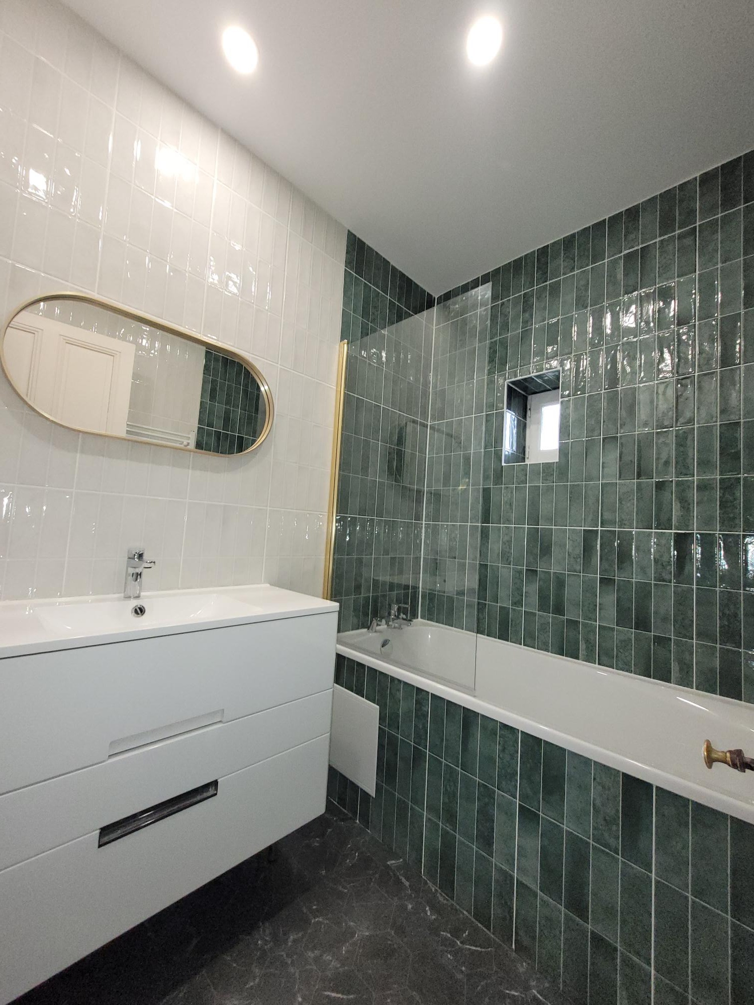 Salle de bain carrelage métro vert avec baignoire